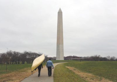 Dave and Amy Freeman portage their canoe “Sig” in front of the Washington Monument, photo by Nate Ptacek