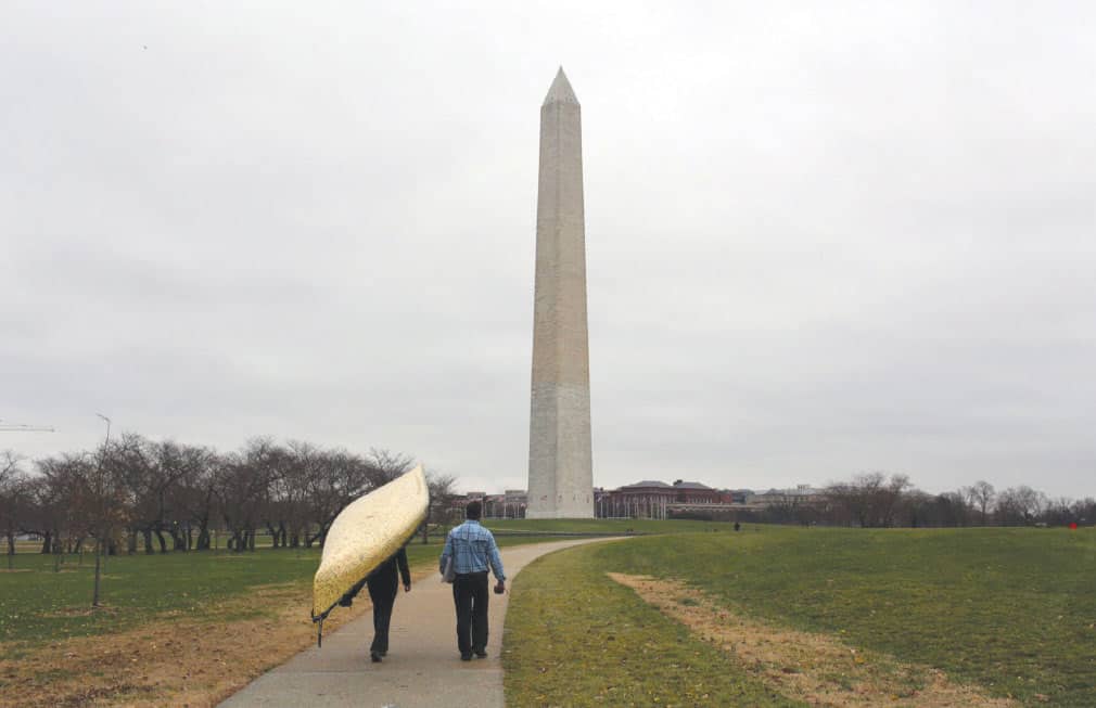 Dave and Amy Freeman portage their canoe “Sig” in front of the Washington Monument, photo by Nate Ptacek