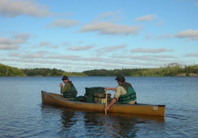 Volunteer Thompson Blodgett (bow) and ranger Curt McEwen paddle on Ensign Lake.