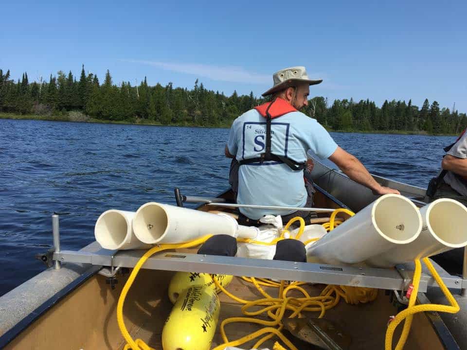 Researcher and University of Minnesota graduate student David Burge paddles a canoe laden with sediment traps on Isle Royale. (Mark Edlund)