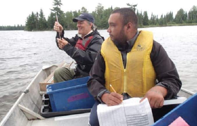 Dakota Lands, Lac La Croix First Nation Fisheries Technician, and Brian Jackson, Quetico Provincial Park Biologist, sample fish populations on Minn Lake in Quetico to assess trends in fish populations. Photo by Conrad Jourdain.