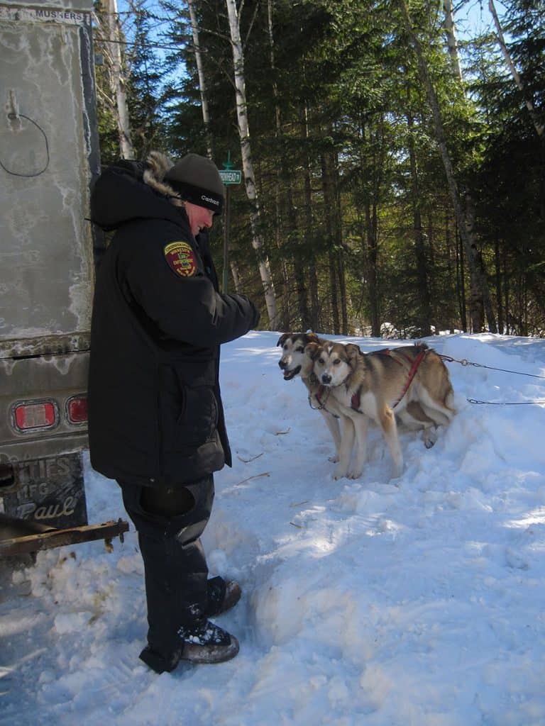 MN DNR conservation officer Mary Manning with her dog team after a winter patrol of the Boundary Waters with the U.S. Forest Service. Photo courtesy Cathy Quinn. 