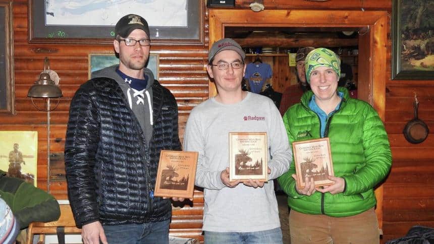 The top three finishers of the Gunflint Mail Run 12-dog race hold their plaques. From left: Ryan Anderson (second place), Ryan Redington (first place) and Erin Redington (third place). Photo courtesy of Gunflint Mail Run via Duluth News Tribune.