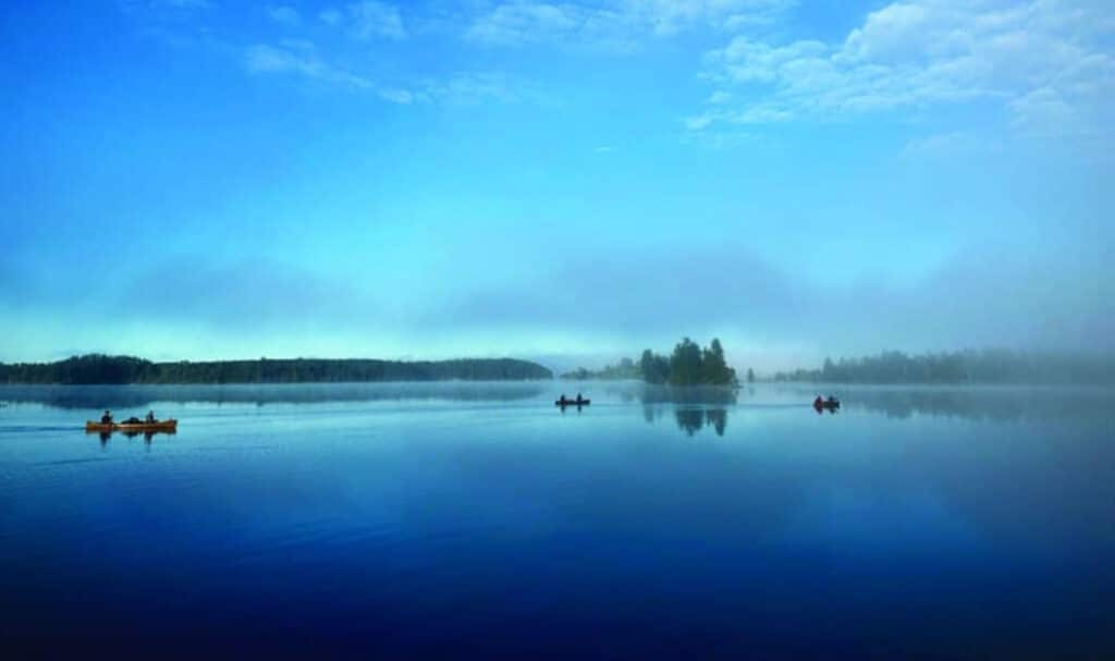 BWCA paddlers on Iron Lake under a bright blue sky
