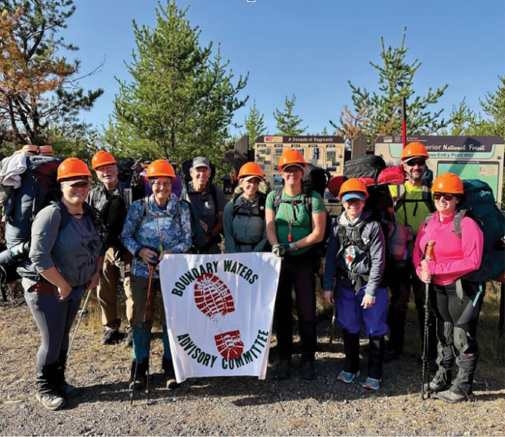 Volunteers that maintain boundary waters hiking trails hold a banner