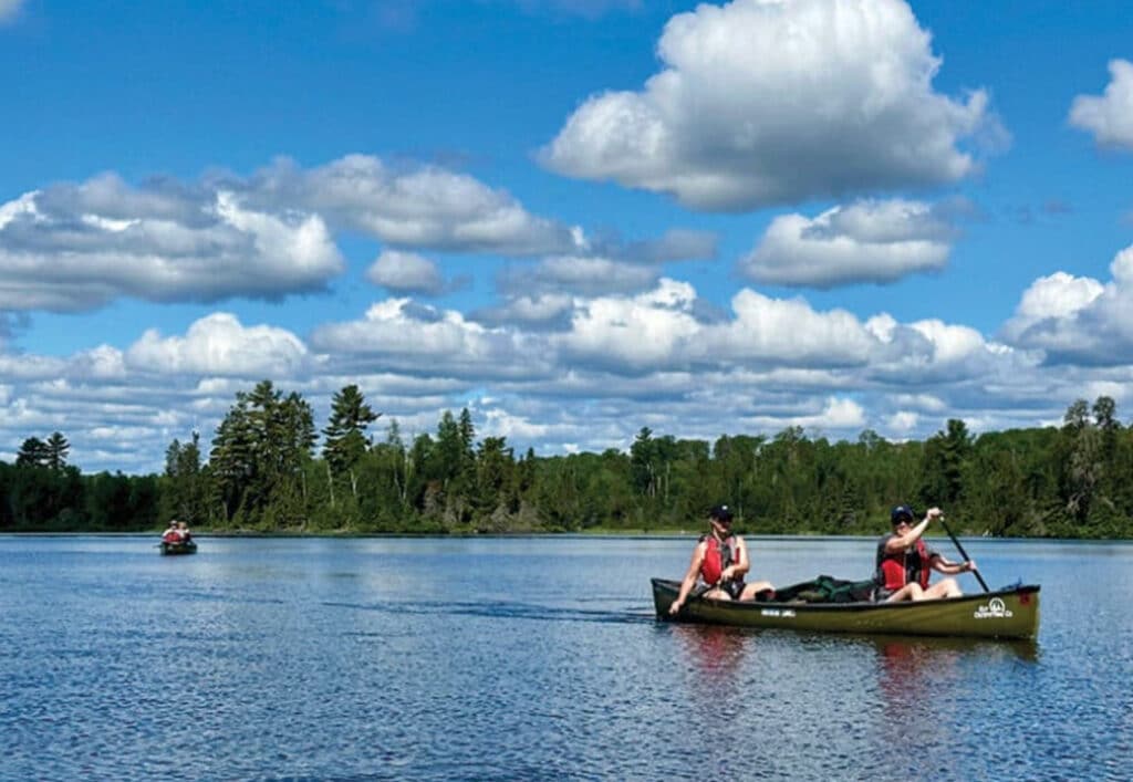 canoeists paddling on Boundary Waters lake
