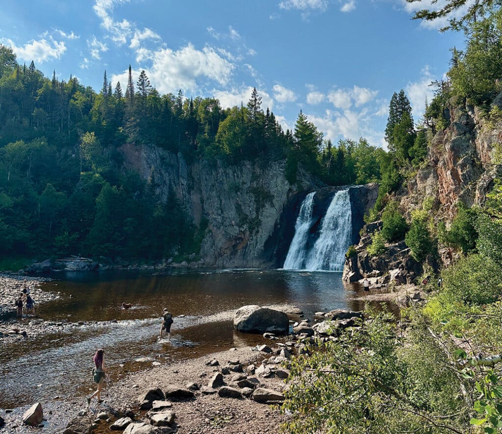 Visitors wade at the foot of High Falls at Tettegouche State Park